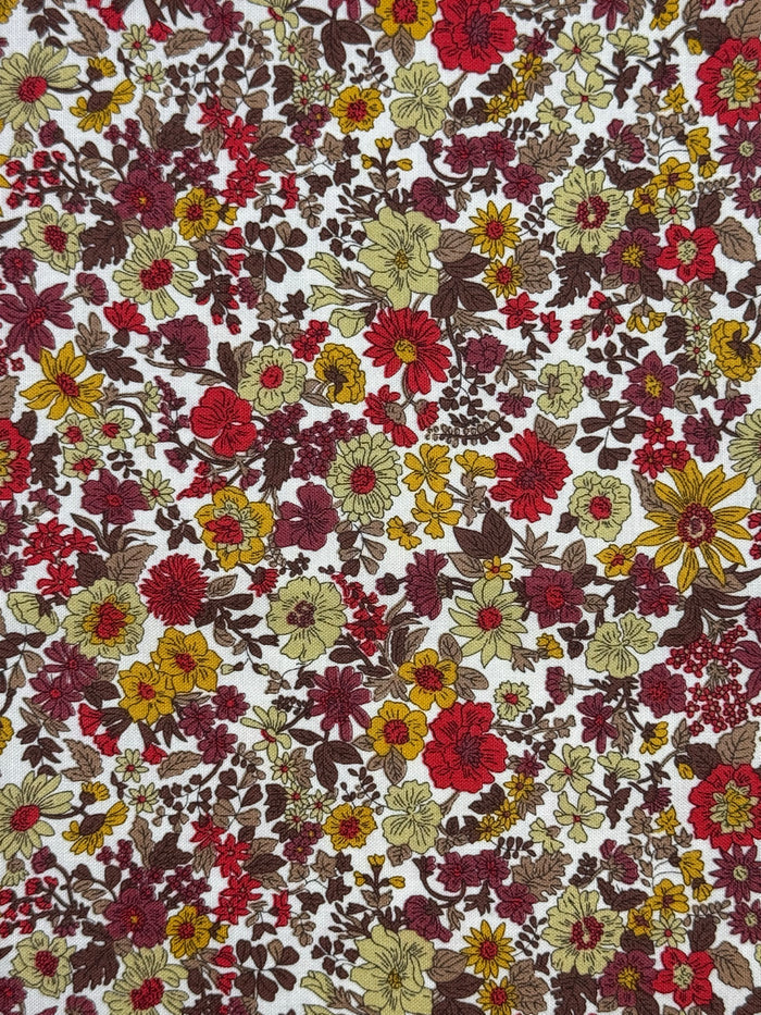 Floral patterned fabric with red, yellow, and green flowers on a white background