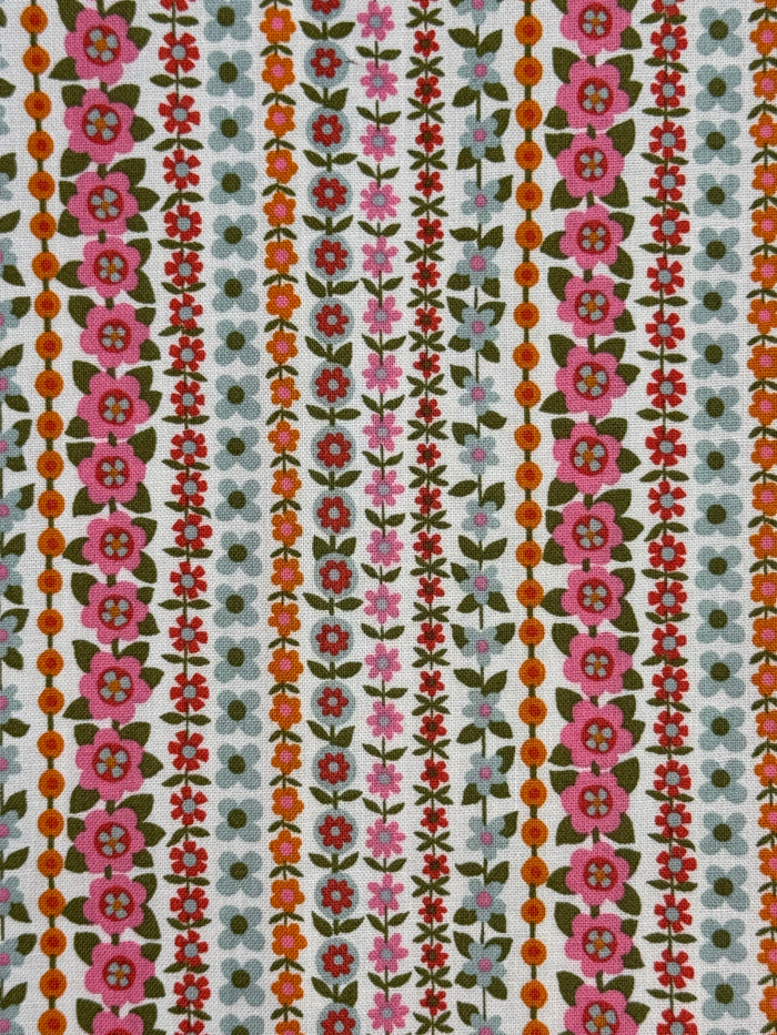 Patterned fabric with floral and geometric designs on a multicolor background