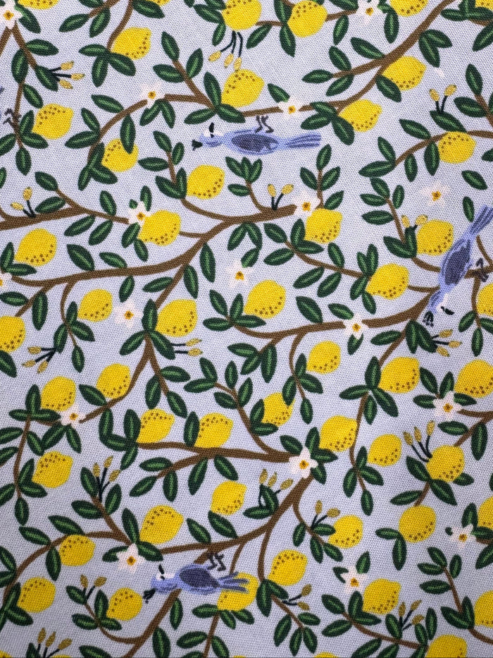 Fabric with lemon and bird pattern on a wooden surface