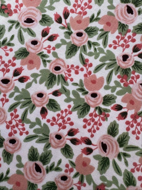 Floral fabric with pink and green pattern on a wooden surface