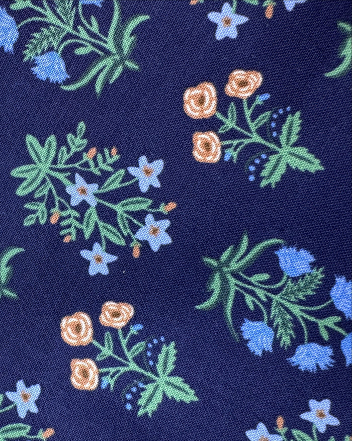Navy blue fabric with floral pattern on a wooden surface