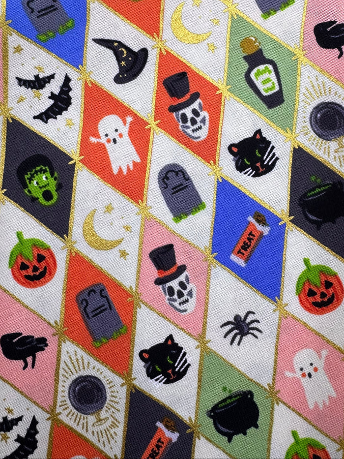 Halloween-themed fabric with various icons on a wooden surface