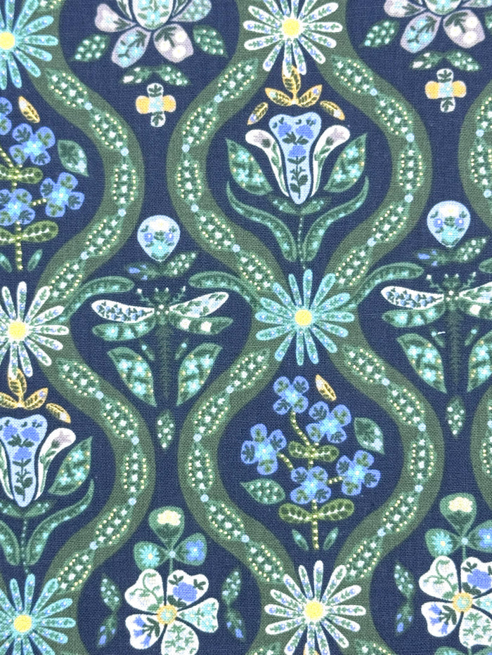 A close-up of a fabric pattern featuring a dark black background with repeating vertical wavy bands in olive green, decorated with stylized flowers, leaves, and small insects in light blue, white, and yellow.