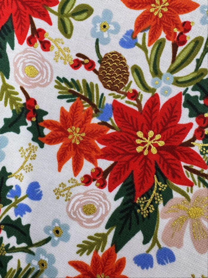 Floral fabric with poinsettias on a wooden surface