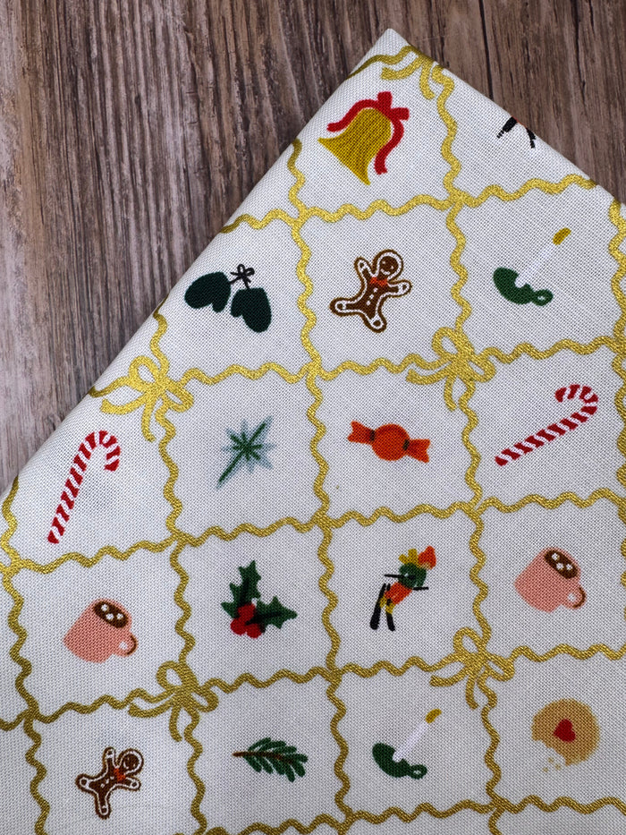 Fabric with Christmas-themed embroidered patterns on a wooden surface
