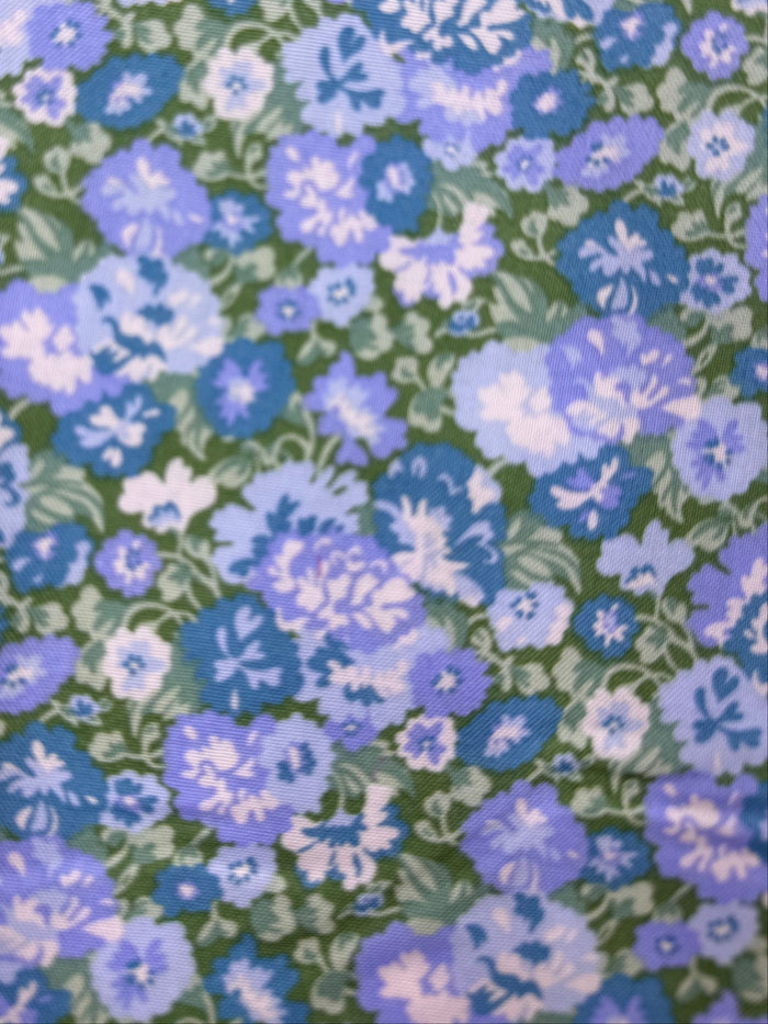 Floral fabric with blue and green pattern on a wooden surface